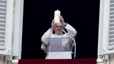 Papież Franciszek w oknie ze świecą Wigilijnego Dzieła Pomocy Dzieciom