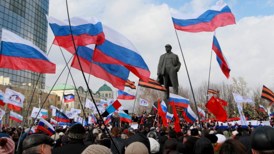 Zgromadzeni na demonstracjach ludzie trzymają flagi Federacji Rosyjskiej i przypinają pomarańczowo-czarne wstążki symbolizujące ruchy prorosyjskie. Fot PAP/EPA