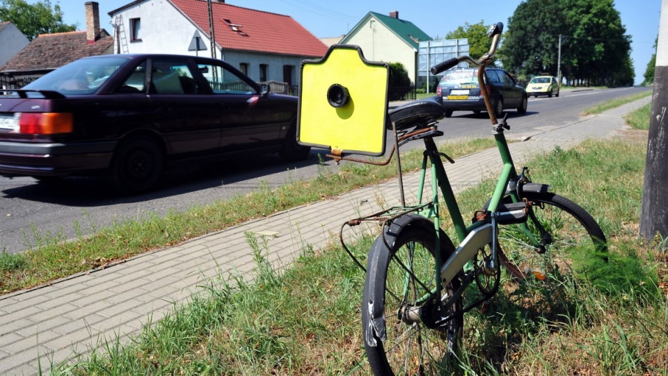 Mieszkaniec gminy ostrzega kierowców znakiem zainstalowanym na rowerze o schowanym fotoradarze. Fot. PAP/Marcin Bielecki