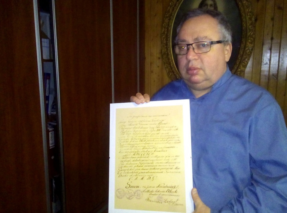 Ksiądz proboszcz Leszek Grzela prezentuje odnaleziony dokument. Fot. Marcin Doliński