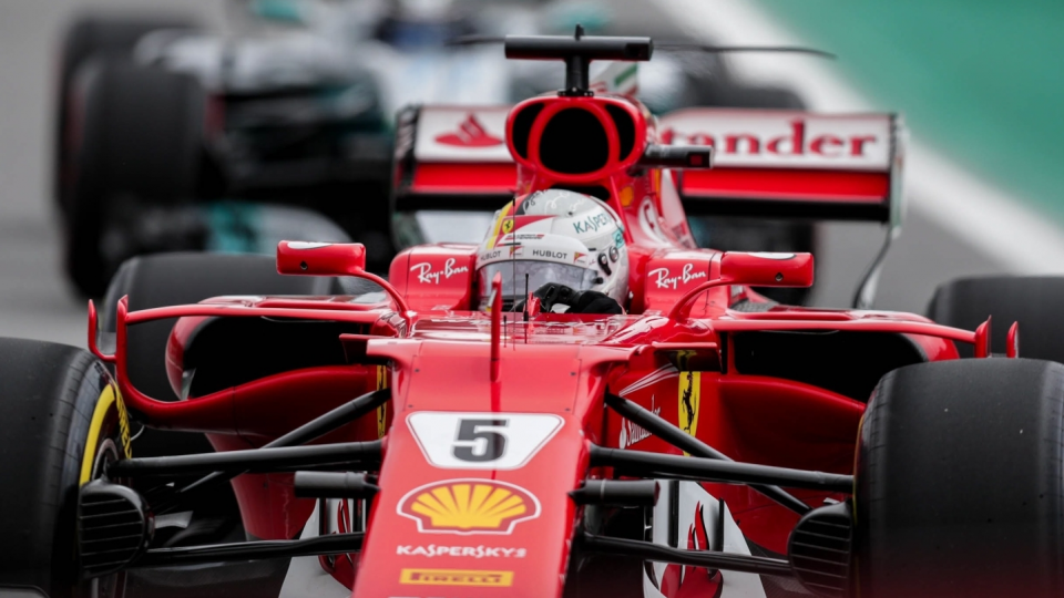 Na pierwszym planie zdjęcia bolid Niemca Sebastiana Vettela podczas Grand Prix Brazylii w Formule 1. Fot. PAP/EPA/FERNANDO BIZERRA JR.