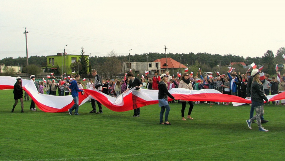 Młodzież rozwinęła flagę na murawie stadionu gminnego w Białych Błotach. Fot. Andrzej Krystek.