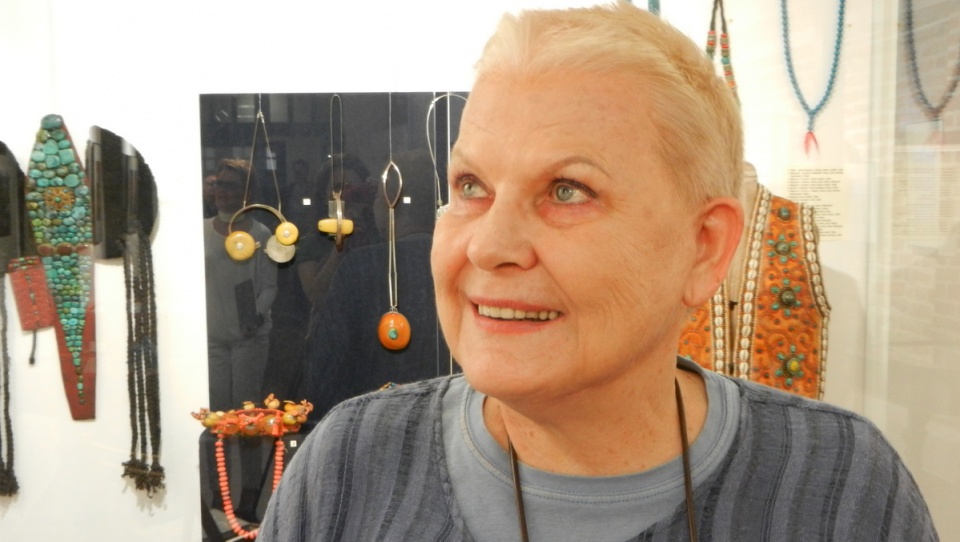 Elżbieta Dzikowska na tle wystawy "Ozdoba czy amulet?" w Muzeum Podróżników. Fot. I. Muszytowska-Rzeszotek