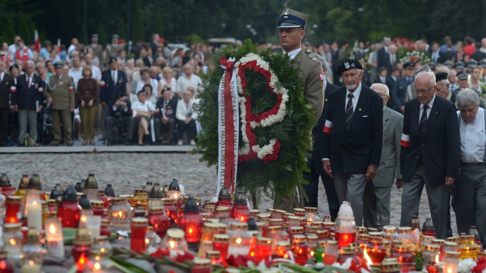 Prezes zarządu głównego Światowego Związku Żołnierzy AK Leszek Żukowski (4P) w towarzystwie powstańców składa kwiaty przed pomnikiem "Polegli Niepokonani". PAP/Radek Pietruszka