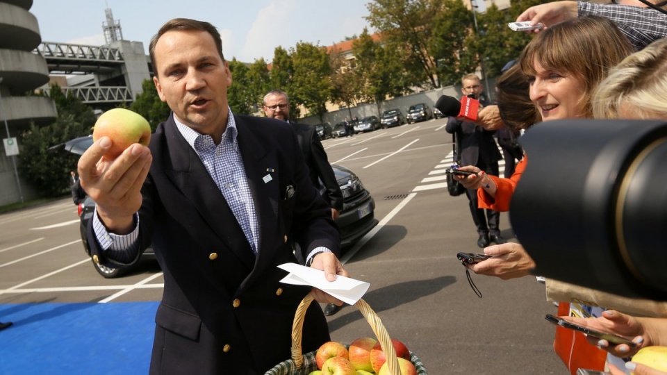 Zanim Sikorski zaczął odpowiadać na pytania, rozdał dziennikarzom polskie jabłka. Fot. PAP/Paweł Supernak