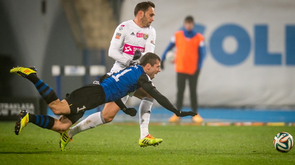 Padający na murawę Sebastian Ziajka i Tomas Hateley w meczu T-Mobile Ekstraklasy. PAP/Tytus Żmijewski