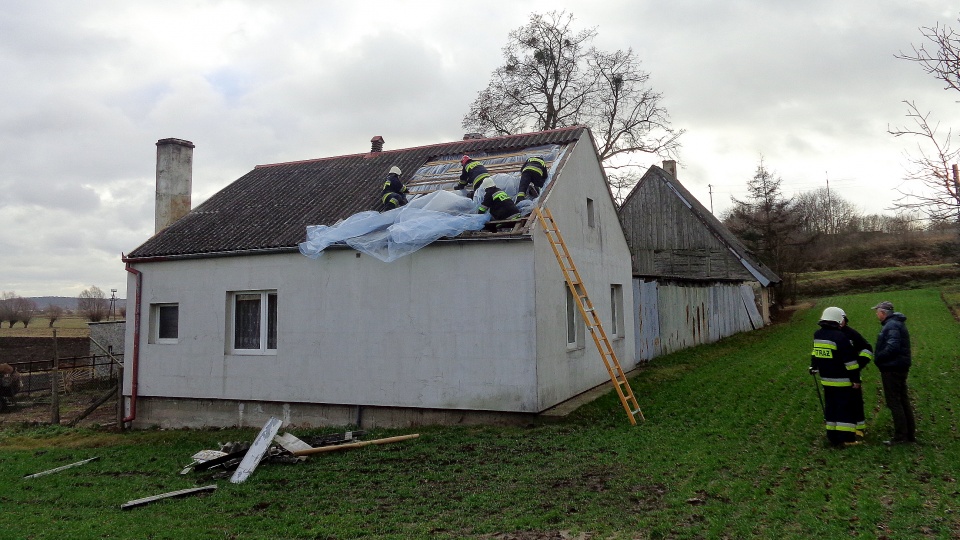 Strażacy zabezpieczają zerwany fragment dachu w budynku w Dragaczu. Fot. Marcin Doliński