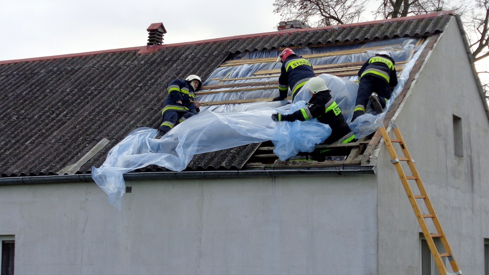 Strażacy zabezpieczają zerwany fragment dachu w budynku w Dragaczu. Fot. Marcin Doliński