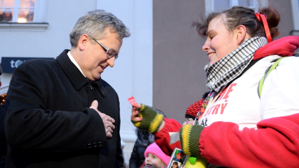 Wolontariuszka przykleja serduszko prezydentowi Bronisławowi Komorowskiemu podczas 23. Finału WOŚP. Fot. PAP/Jacek Turczyk