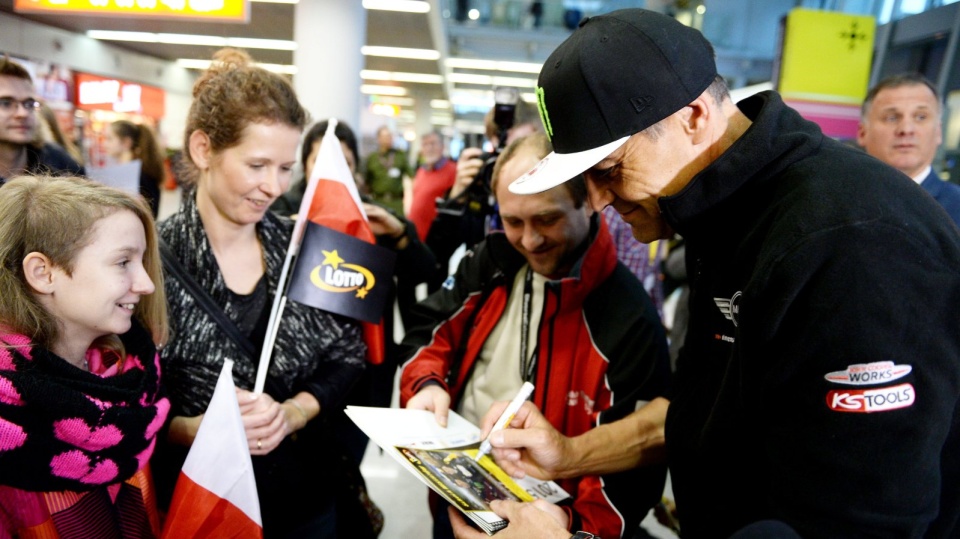 Krzysztof Hołowczyc rozdaje autografy fanom na warszawskim lotnisku Okęcie. Fot. PAP/Bartłomiej Zborowski