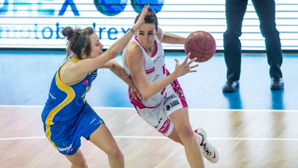 zarżująca z piłką Katarzyna Krężel (P) z miejscowego Artego blokowana przez Anne Jakubiuk (L) z Basketu Gdynia. Fot. PAP/Tytus Żmijewski