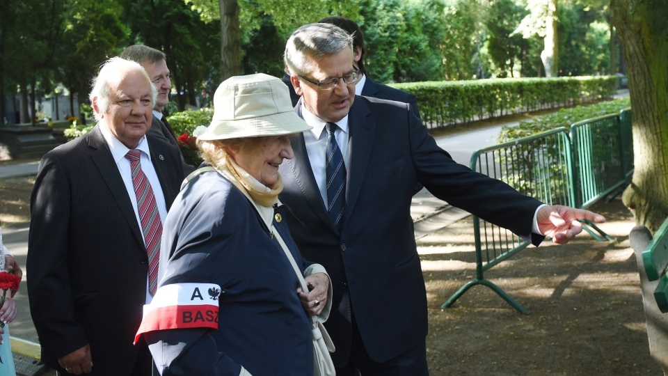 Prezydent Bronisław Komorowski (P), jego ciotka Halina Wołłowicz (C), łączniczka i sanitariuszka "Rena" w kompanii K-1 pułku "Baszta" i syn gen. Tadeusza Bora - Komorowskiego, Adam Komorowski (L) złożyli kwiaty na grobach powstańców na Wojskowym Cmentarzu Powązkowskim. Fot. PAP/Radek Pietruszka