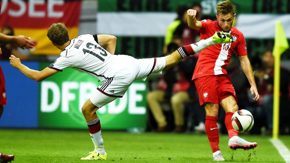 Maciej Rybus (P) i strzec gola dla gospodarzy Niemiec Thomas Mueller (L) w eliminacyjnym meczu grupy D piłkarskich mistrzostw Europy 2016 na Commerzbank Arena we Frankfurcie. Fot. PAP/Bartłomiej Zborowski