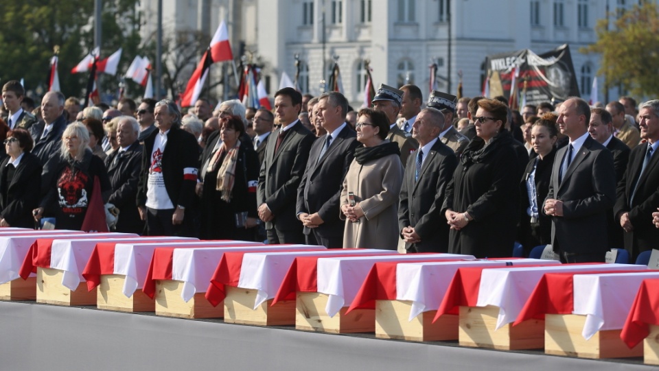 Premier Ewa Kopacz (C), wicepremier, minister obrony narodowej Tomasz Siemoniak (2L), minister kultury Małgorzata Omilanowska (P), szef KPRM Jacek Cichocki (L) i Sekretarz Rady Ochrony Pamięci Walk i Męczeństwa Andrzej Kunert (2P) uczestniczą w mszy żałobnej na placu Marszałka Józefa Piłsudskiego w Warszawie. Przy ołtarzu wystawiono 35 trumien ze szczątkami ofiar. Fot. PAP/Rafał Guz