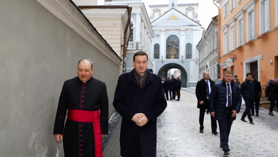 Premier Mateusz Morawiecki (2L) i proboszcz kościoła pw. św. Teresy i rektor Kaplicy Ostrobramskiej w Wilnie Kestutis Latoza (L) podczas spaceru ulicami Wilna. Fot. PAP/Rafał Guz