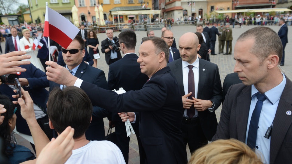 Obchody Dnia Flagi RP oraz Dnia Polonii i Polaków za Granicą - prezydent Andrzej Duda rozdaje flagi po uroczystym podniesieniu Flagi Państwowej RP na Wieży Zegarowej Zamku Królewskiego w Warszawie. Fot. PAP/Jakub Kamiński