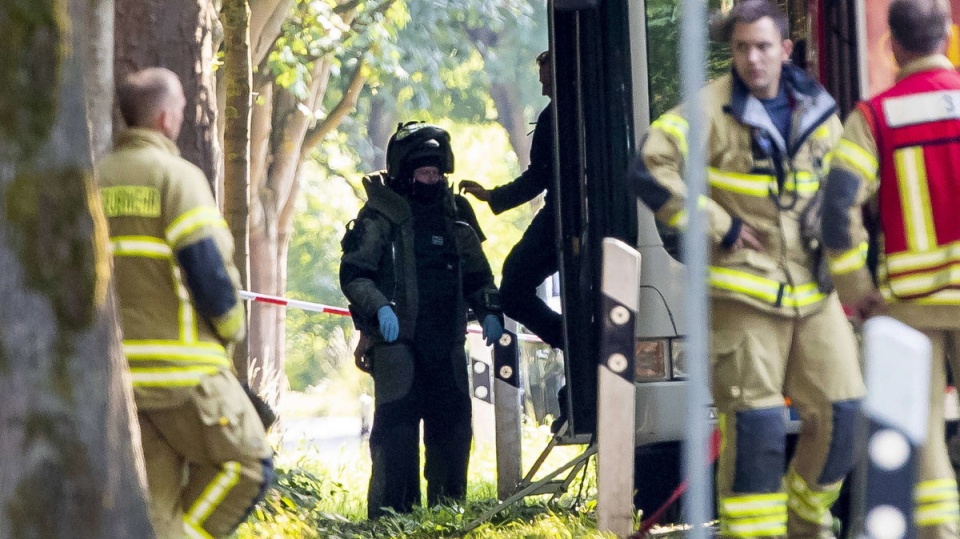 Saperzy badają plecak znaleziony w części przegubowej autobusu. Fot. PAP/EPA/CHRISTIAN SCHAFFRATH