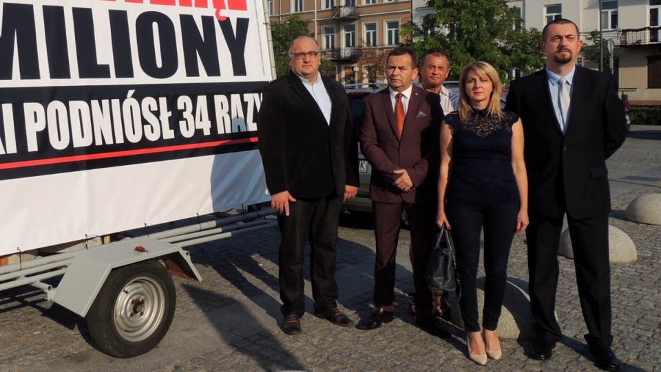 Włocławscy działacze Platformy Obywatelskiej i .Nowoczesnej w trakcie konferencji prasowej na tle bilbordu. Fot. Marek Ledwosiński