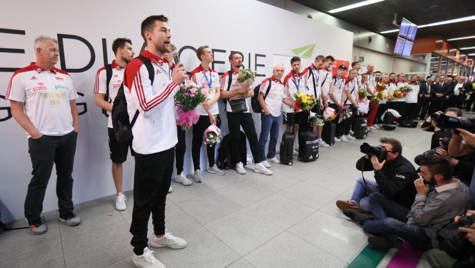 Na pierwszym planie zdjęcia kapitan siatkarskiej reprezentacji Polski Michał Kubiak podczas powitania na warszawskim lotnisku Okęcie. Fot. PAP/Leszek Szymański