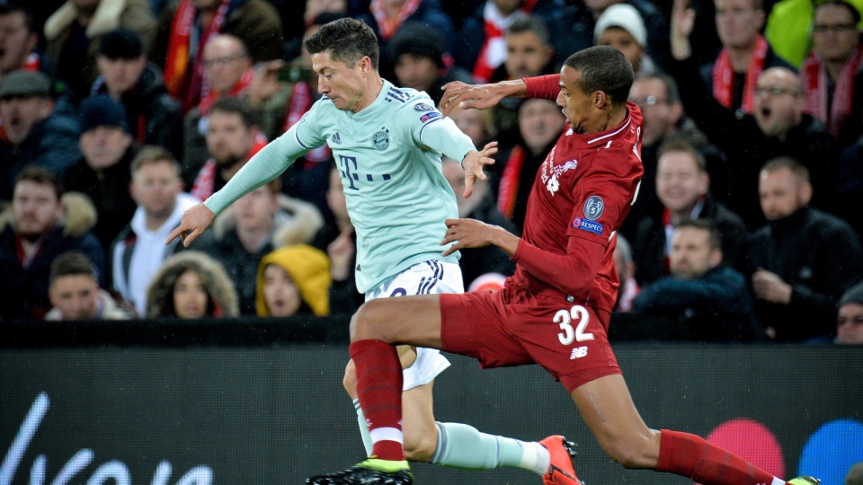 Na zdjęciu od lewej Robert Lewandowski w walce o piłkę podczas meczu FC Liverpool kontra Bayern Monachium w 1/8 finału Ligi Mistrzów 2018/2019. Fot. PAP/EPA/PETER POWELL