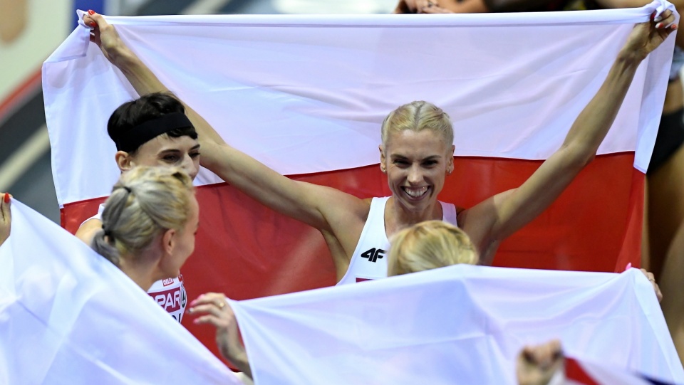 Iga Baumgart-Witan (na zdjęciu z rozłożoną polską flagą) cieszy się z koleżankami ze złotego medalu lekkoatletycznych HME w Glasgow w sztafecie 4x400 metrów. Fot. PAP/Adam Warżawa