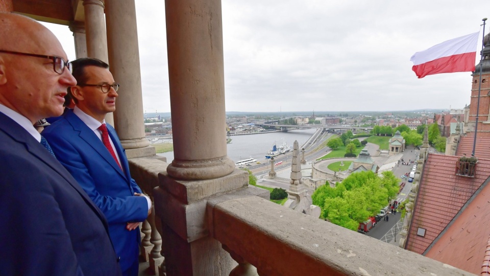 Premier Mateusz Morawiecki (2L) oraz minister spraw wewnętrznych i administracji Joachim Brudziński (L) podczas uroczystości podniesienia flagi państwowej na budynku Zachodniopomorskiego Urzędu Wojewódzkiego w Szczecinie. W całej Polsce obchodzony jest Dzień Flagi RP. Fot. PAP/Marcin Bielecki