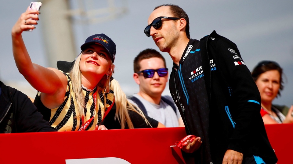 Na zdjęciu od prawej Robert Kubica, który jeszcze przed niedzielnym Grand Prix Hiszpanii pozował do pamiątkowych zdjęć z fanami. Fot. PAP/EPA/ENRIC FONTCUBERTA