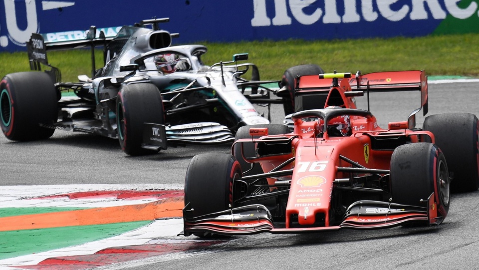 Na pierwszym planie zdjęcia bolid Ferrari z Charlesem Leclerciem na pokładzie podczas wyścigu o Grand Prix Włoch. Fot. PAP/EPA/DANIEL DAL ZENNARO