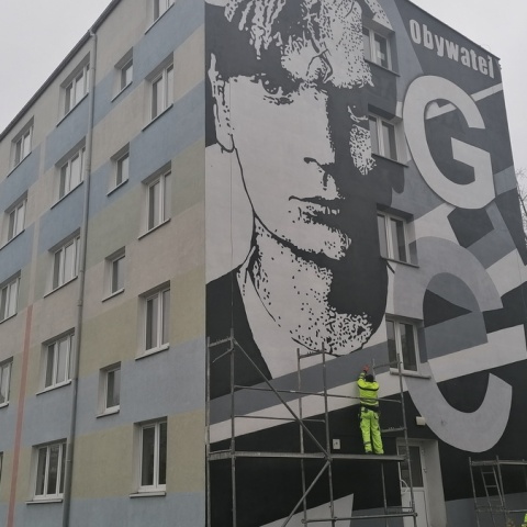Czarno-biały, upamiętnia Grzegorza Ciechowskiego. Mural na budynku UMK