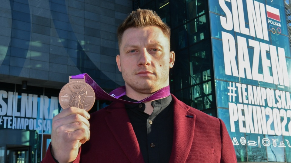 Sztangista Tomasz Zieliński pozuje do zdjęcia z brązowym medalem igrzysk olimpijskich w Londynie, który odebrał 21 bm. w siedzibie Polskiego Komitetu Olimpijskiego w Warszawie. Na igrzyskach olimpijskich w Londynie w 2012 r. Zieliński zajął 9. miejsce. Po dyskwalifikacji innych zawodników w 2017 przyznano mu trzecie miejsce. Fot. PAP/Piotr Nowak