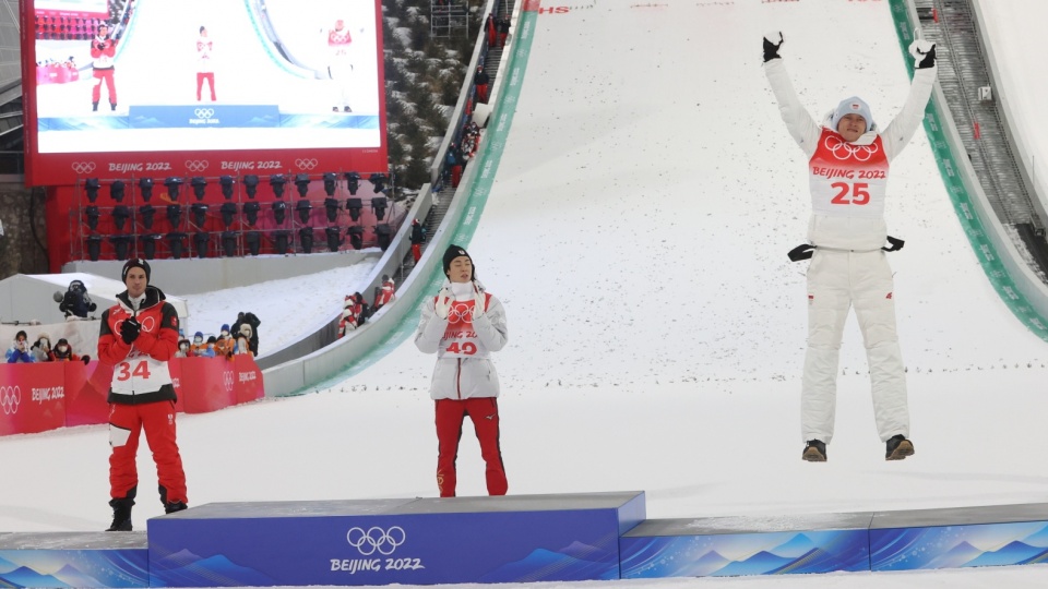Austriak Manuel Fettner (L), Japończyk Ryoyu Kobayashi (C) i Polak Dawid Kubacki (P) podczas ceremonii kwiatowej na podium konkursu skoków narciarskich na obiekcie normalnym w Zhangjiakou. Fot. PAP/Grzegorz Momot