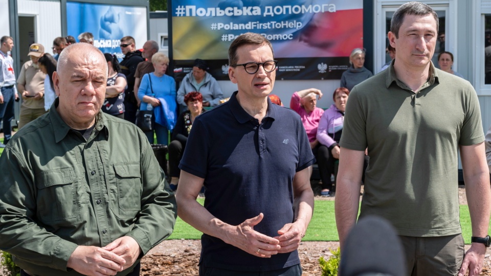 Premier Mateusz Morawiecki ( w środku), wicepremier, minister aktywów państwowych Jacek Sasin (z lewej) oraz minister rozwoju gmin i terytoriów Ukrainy Ołeksij Czernyszow podczas wizyty w miasteczku kontenerowym dla uchodźców wewnętrznych w Borodziance k. Kijowa. Fot. PAP/Viacheslav Ratynskyi