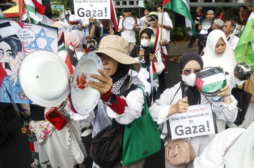 Muzułmanki z Indonezji uderzają sztućcami podczas protestu przed ambasadą Egiptu w Dżakarcie, Indonezja, 2 sierpnia 2025 r. Dziesiątki indonezyjskich muzułmanów organizuje wiec, w którym wzywa rząd Egiptu do otwarcia granicy, aby umożliwić napływ pomocy humanitarnej do Strefy Gazy/ fot. BAGUS INDAHONO/PAP/EPA.