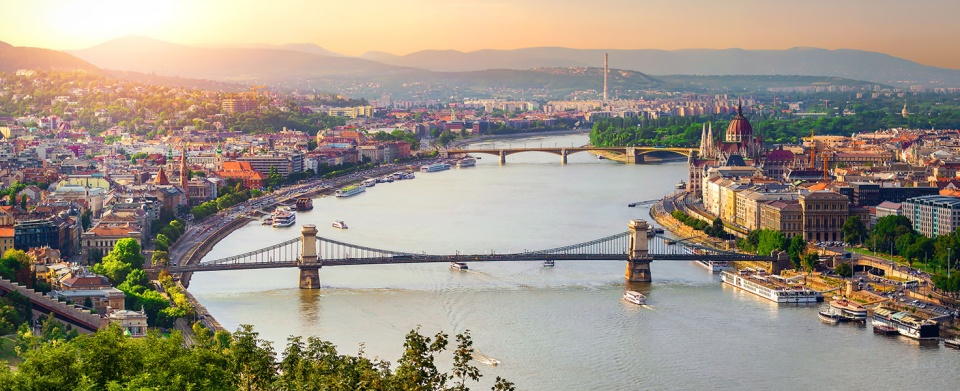 Materiały promocyjne - Widok na Budapeszt i most Łańcuchowy nad Dunajem o zachodzie słońca.