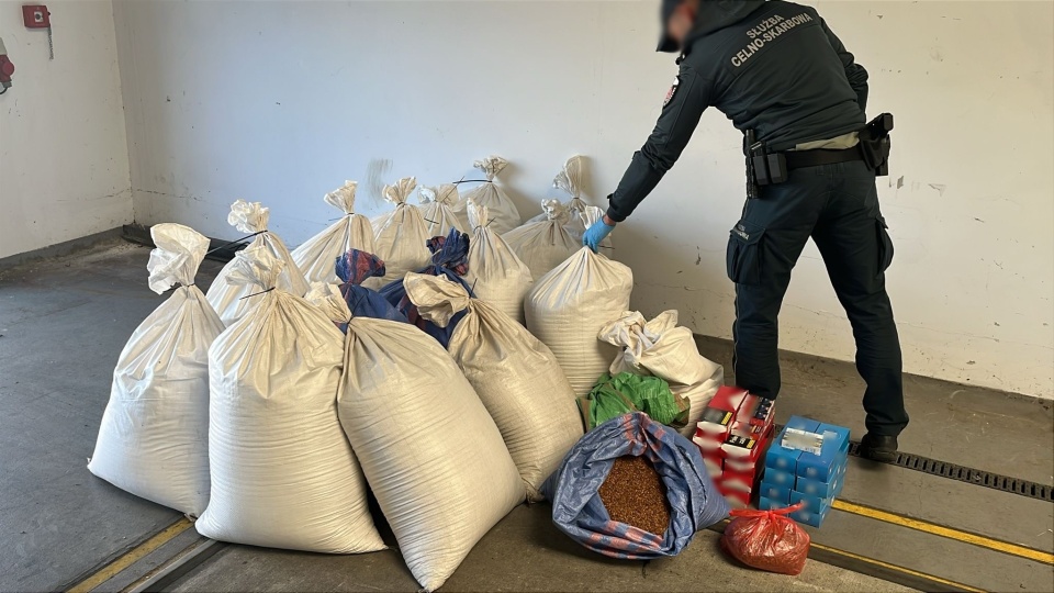 Na terenie posesji oraz w garażu należącym do kierowcy, funkcjonariusze KAS znaleźli 18 worków zawierających ponad 156 kg tytoniu do palenia, a także 2580 sztuk papierosów nieposiadających znaków akcyzy/fot. KAS