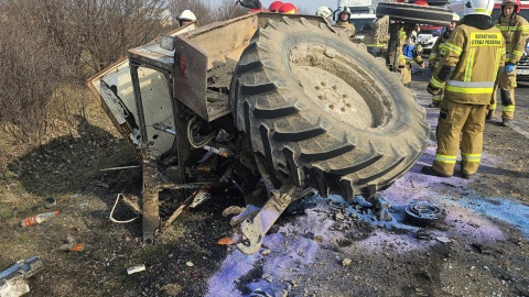 Na miejscu zdarzenia strażacy zastali dwa pojazdy: busa i przewrócony ciągnik z urwanym tylnym kołem leżący na poboczu/fot. Komenda Powiatowa Państwowej Straży Pożarnej w Radziejowie/Facebook