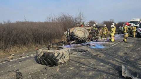 Na miejscu zdarzenia strażacy zastali dwa pojazdy: busa i przewrócony ciągnik z urwanym tylnym kołem leżący na poboczu/fot. Komenda Powiatowa Państwowej Straży Pożarnej w Radziejowie/Facebook