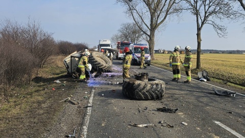 Na miejscu zdarzenia strażacy zastali dwa pojazdy: busa i przewrócony ciągnik z urwanym tylnym kołem leżący na poboczu/fot. Komenda Powiatowa Państwowej Straży Pożarnej w Radziejowie/Facebook