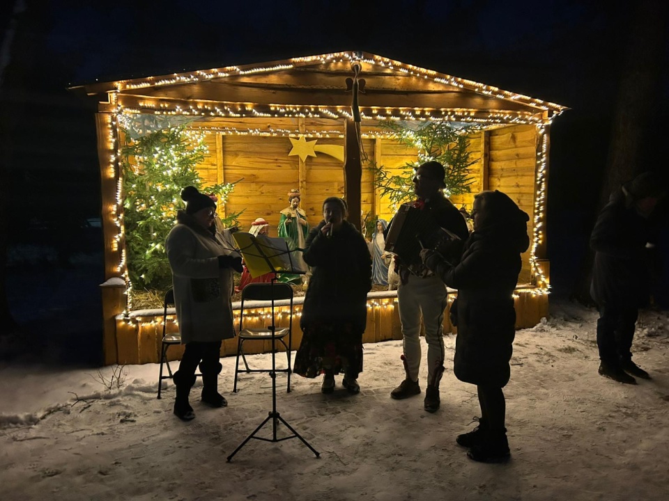 W Lubiczu Dolnym, przy padającym śniegu, obok stajenki bożonarodzeniowej i z akompaniamentem góralskich instrumentów odbyło się śpiewanie kolęd i pastorałek/fot. Robert Duliński